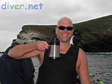 Roger Carlson with his all important cup of coffee, Arch Point in the background. 
