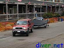 Eric Sedletzky tows his boat by the businesses at Arena Cove on the way to the lift on the pier.