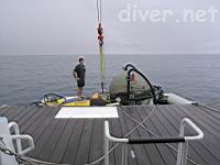 Ofer Ketter inspects the hoist attachment to Deep See before it is hoisted back onto the Sea Hunter for the night